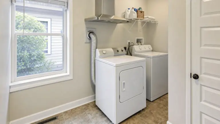 A compact laundry area shows the dryer, washer, and vent path where long dry times can start.